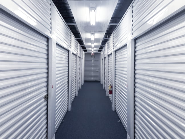 Brightly lit indoor storage units in a long hallway