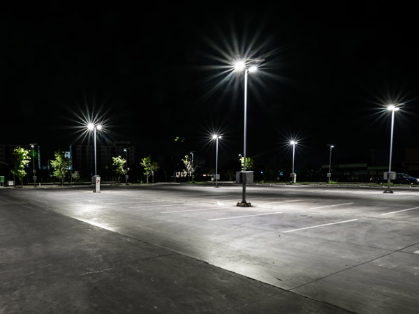 An empty parking lot being lit by LED light poles