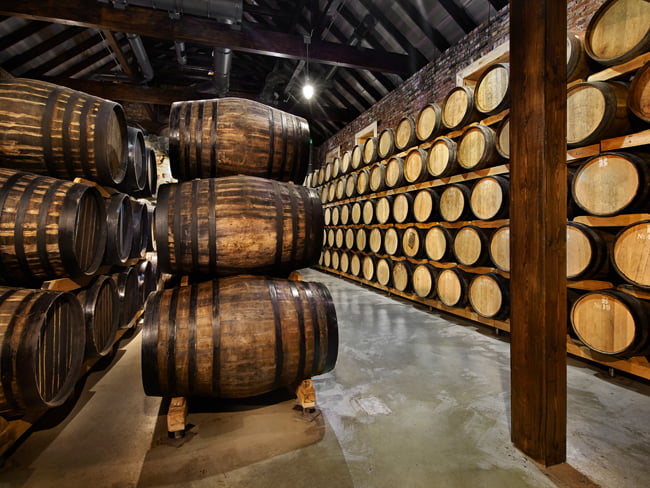 Distillery full of whiskey barrels being illuminated by jelly jar lights