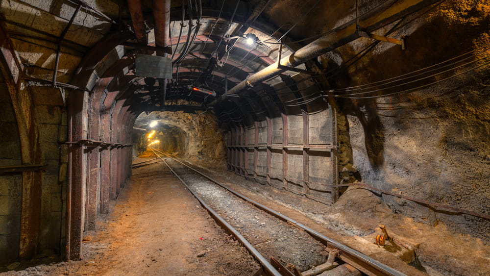 A long coal mine tunnel being illuminated by lights