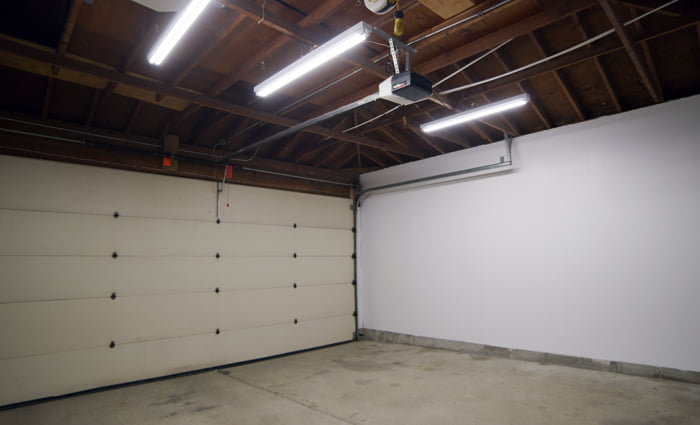 3 LED Strip fixtures hanging in a garage, illuminating the area