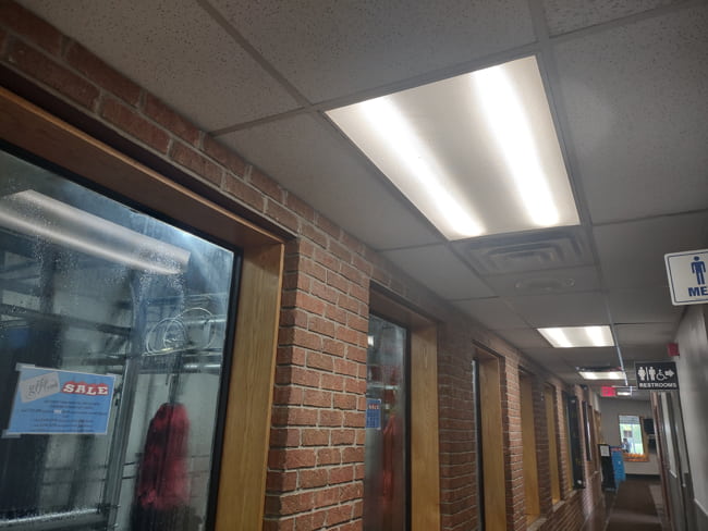 Ceiling troffer lights illuminating the hallway of a waiting area inside a car wash