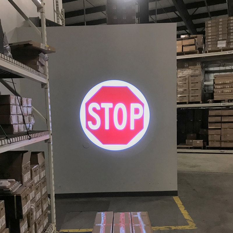 A stop sign symbol is illuminated onto an open door using a logo projector light